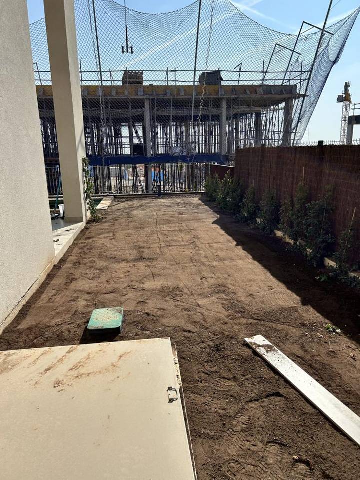 Jardín antes de la obra: terreno de tierra preparado